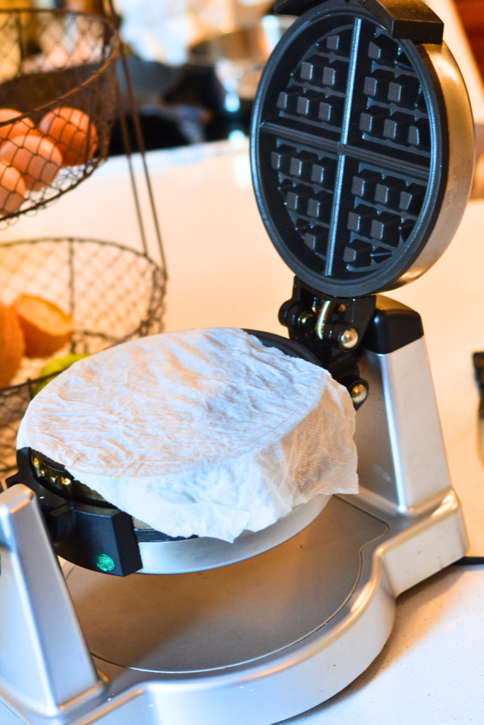 a clean waffle maker; open with a paper towel laid across the waffle iron