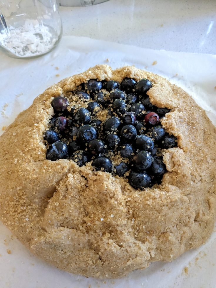 a delicious and rustic-looking blueberry galette topped with turbinado sugar